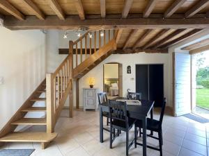 een eetkamer met een trap en een tafel en stoelen bij Brecat in Saint-Faust