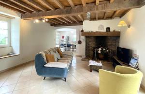 een woonkamer met een bank en een open haard bij Brecat in Saint-Faust