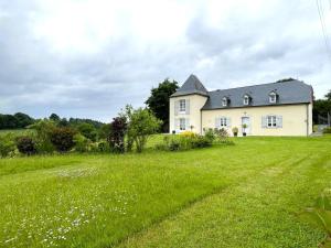 een groot wit huis met een groot grasveld bij Brecat in Saint-Faust