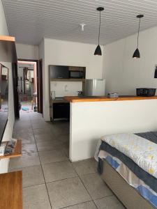 a room with a kitchen with a counter and a bed at Aconchego in Pelotas