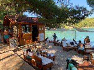 un groupe de personnes assises autour d'un bar au bord de l'eau dans l'établissement Quirky Penthouse Apartment, à Vrboska