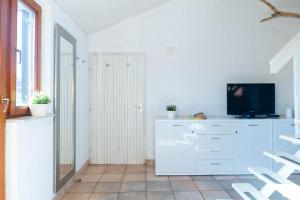 - un salon avec une télévision sur une commode blanche dans l'établissement Quirky Penthouse Apartment, à Vrboska