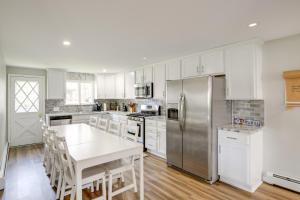 a kitchen with white cabinets and a stainless steel refrigerator at 1 Mi to Lake Erie Family-Friendly Angola Home! in Angola