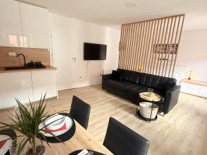 un soggiorno con un divano nero e un tavolo di Apartments KrAnJ - City Studio Katka a Kranj