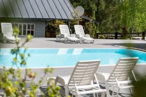 a group of white chairs next to a swimming pool at Cabanele Doi Frati in Dealu Negru +7 photos