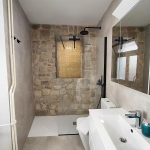 uma casa de banho com um lavatório branco e uma parede de pedra em Casa della Fortuna by Locap Group em Piran