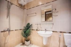a bathroom with a sink and a plant in it at Mustang 11-11 Boutique Hotel Self Check In in Ho Chi Minh City