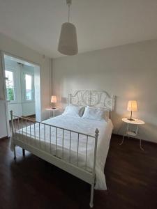 a bedroom with a white bed with two tables and two lamps at La Terrazza degli Angeli Guest House in Santa Maria degli Angeli