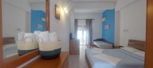 a living room with two beds and a mirror at Paraga Rooms Pefkari in Pefkari