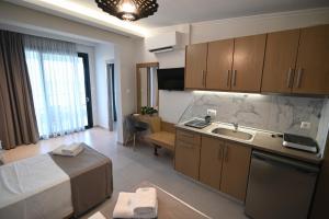 a kitchen with a sink and a couch in a room at SKYLINE Fine Living in Nei Poroi +101 photos