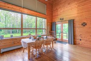 a dining room with a table and chairs and windows at Near State Parks Countryside Cottage in Wellsboro in Wellsboro