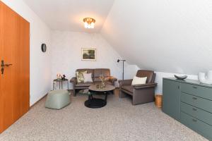 a living room with two chairs and a table at Haus Strandlooper in Neuharlingersiel