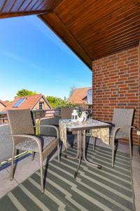 a patio with a table and chairs on a balcony at Haus Strandlooper in Neuharlingersiel