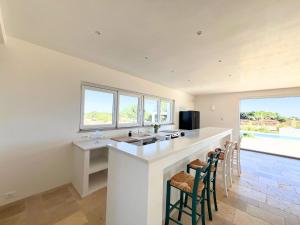 a kitchen with a sink and a counter with chairs at Residenza del Duca in Martina Franca