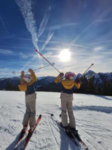 two people on skis in the snow holding their poles at Lake View Lodge in Flachau