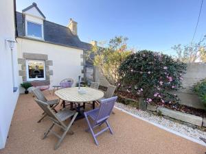 eine Terrasse mit Tisch und Stühlen vor einem Haus in der Unterkunft Belle maison avec jardin clos proche plage à l'ILE GRANDE - Réf 291 in Pleumeur-Bodou + 19 Fotos