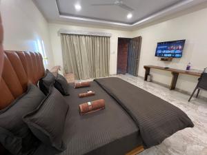 une chambre avec un grand lit et une télévision dans l'établissement Sabas Tent & Cottages, à Mahabaleshwar