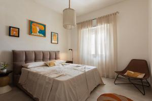 Un dormitorio con una cama grande y una silla. en Casa Due Fichi, en San Pietro in Bevagna 30 fotos más