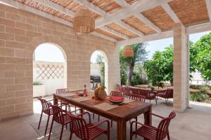 Un patio al aire libre con una mesa y sillas de madera. en Casa Due Fichi, en San Pietro in Bevagna