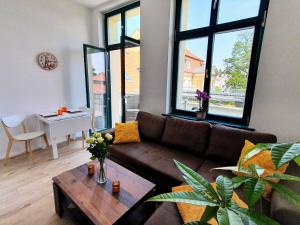 ブランデンブルク・アン・デア・ハーフェルにあるHogulu - 2 - RAUM - App 23 mit Balkon im Herzen der Altstadtのソファとテーブルのあるリビングルーム +11枚の写真