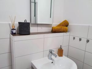 ブランデンブルク・アン・デア・ハーフェルにあるHogulu - 2 - RAUM - App 23 mit Balkon im Herzen der Altstadtの洗面台と鏡のある白いバスルーム