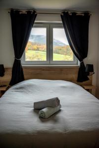 a towel laying on a bed in front of a window at Hohwarth - Le Contemporain - Logement 6 personnes in Saint-Pierre-Bois