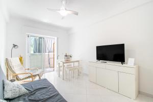 a living room with a flat screen tv on a cabinet at HolidaysPT - Casa da Ria - 2 Bedroom Apartment in Fuzeta