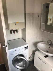 ein kleines Badezimmer mit Waschmaschine und Waschbecken in der Unterkunft HagenStay Mittelstadt 1 in Hagen