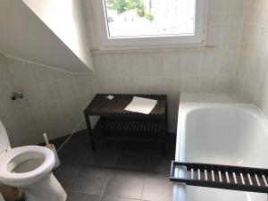 ein Badezimmer mit Toilette und Waschbecken und einem Fenster in der Unterkunft HagenStay Mittelstadt 1 in Hagen