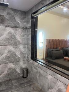 a bathroom with a mirror and a bed in a room at ARANYAM By StarGlaze Retreat in Mahabaleshwar