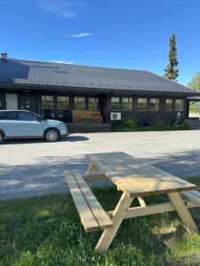 a picnic table in front of a building with a car at Karivollen Overnatting in Melhus