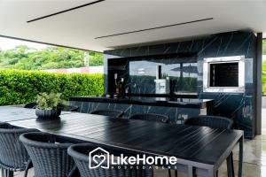 a patio with a table and chairs and a kitchen at Unity Cabo Branco - LikeHome Hospedagens in João Pessoa
