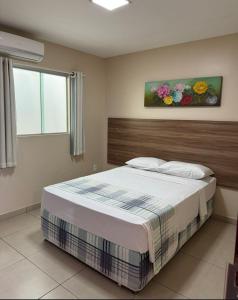 a bedroom with a bed and a painting on the wall at Moda Center Hotel in Santa Cruz do Capibaribe