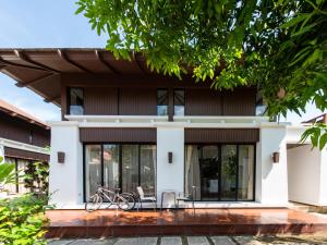 a house with a bike parked in front of it at Ban Talay Beach House Rayong Thailand in Ban Pak Nam Krasae