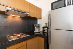 a kitchen with a refrigerator and wooden cabinets at Ban Talay Beach House Rayong Thailand in Ban Pak Nam Krasae