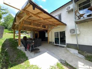 a wooden pergola on the side of a house at La Burlacu in Eşelniţa