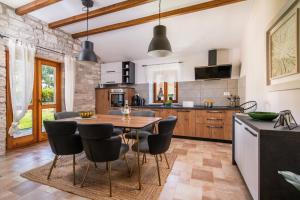 a kitchen with a wooden table and chairs at Villa Orada for 6 people with private pool & only 2,5 km from the beach in Krnica