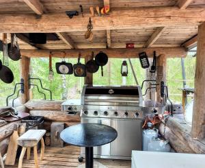 an outdoor kitchen with a stove and a table at Kuukkelin Koto in Hämeenlinna