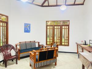 a room with chairs and windows and a table at Crystal Wave in Weligama