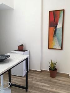 a workspace with a desk and a painting on the wall at Alana's loft in Praia