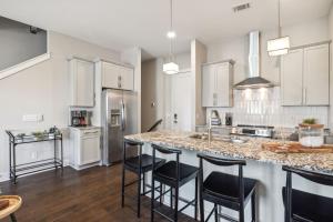 a kitchen with a large island with bar stools at Country Music Themed Goodrich Ave by SkyRun Nashville in Nashville