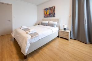 a bedroom with a large bed and a painting on the wall at Elegant Sea View Stay - Piraeus Port in Piraeus