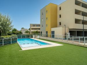 an outdoor swimming pool in front of a building at La Dune 54 - Villa 3P6 in Valras-Plage