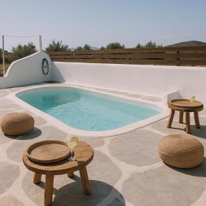 una piscina con due tavoli e due sedie di Boho Sisi Resort - Poolside Oasis & Garden Vibes ad Ágios Nikólaos