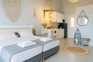 a bedroom with a large bed and a kitchen at Boho Sisi Resort - Poolside Oasis & Garden Vibes in Agios Nikolaos