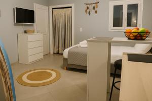 a bedroom with a bed and a table with a bowl of fruit at Boho Sisi Resort - Poolside Oasis & Garden Vibes in Agios Nikolaos
