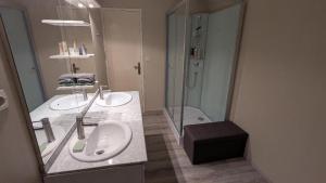 a bathroom with two sinks and a shower at Terres du Milieu in Saint-Mayme-de-Pereyol
