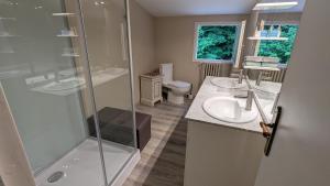 a bathroom with two sinks and a shower at Terres du Milieu in Saint-Mayme-de-Pereyol