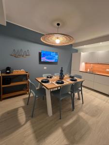 een eetkamer met een tafel en stoelen en een keuken bij Appartamento Gocce di sole in Pietra Ligure +12 foto's