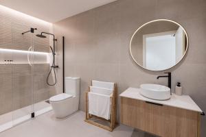 a bathroom with a toilet and a sink and a mirror at Loft América 41 A in Melide
